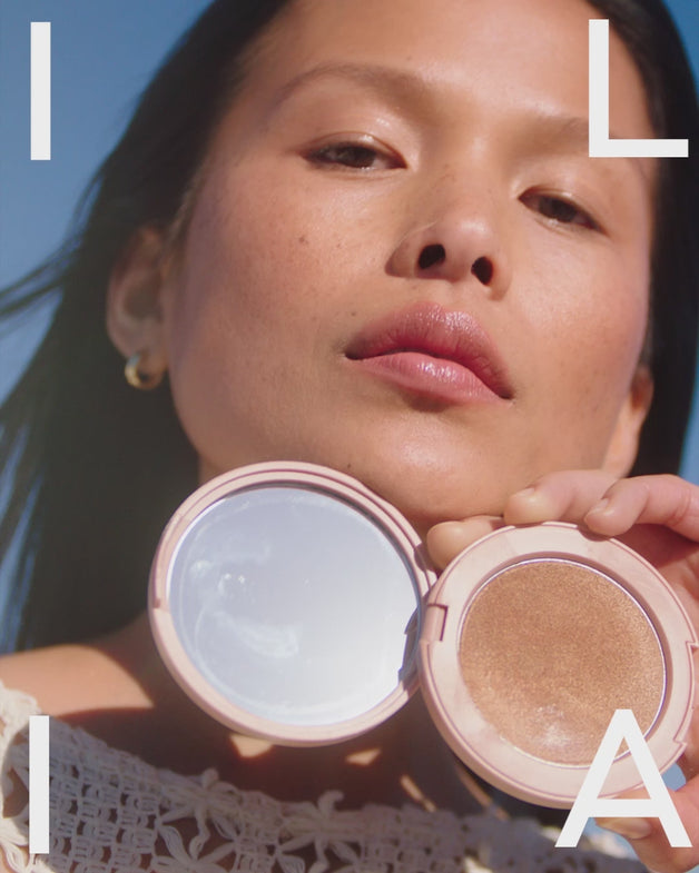 Models showing the ILIA bronzer and highlighter being applied to their faces using the Sculpting Brush.