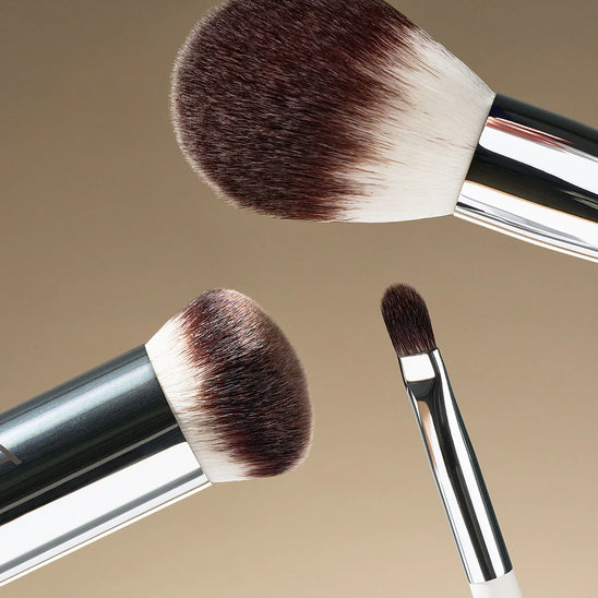 Three assorted 官方澳洲幸运5 brushes set against a soft tan gradient.