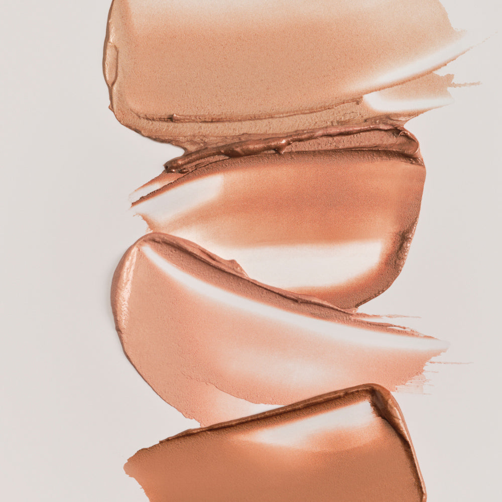 Swatches of ILIA's Lightshift Cream Highlighter swatched on a grey background.